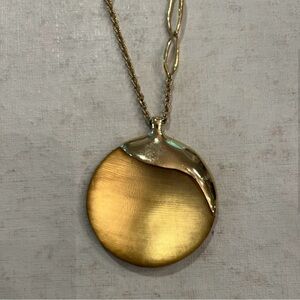 Alexis Bittar gold lucite medallion pendant with mixed link gold-tone chain.